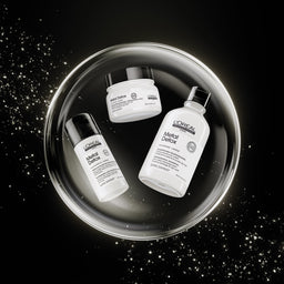 Three L'Oréal Paris Metal Detox skincare products arranged inside a glowing circular metallic tray on a black background with sparkling light effects.