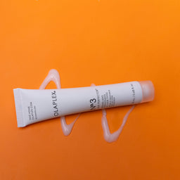 L'Oreal Paris hair product tube on an orange background