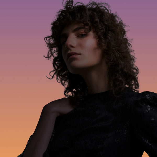Woman with curly hair against a gradient background