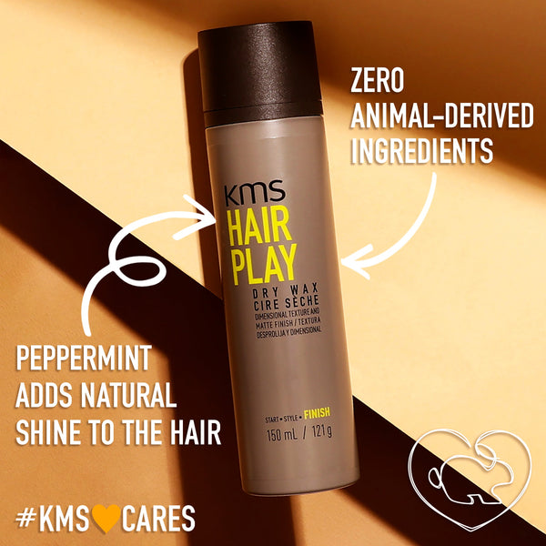 KMS Hair Play dry wax bottle with text highlighting zero animal-derived ingredients and peppermint benefits on a brown background.
