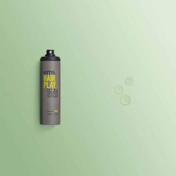KMS Hair Play hair spray bottle on a green background