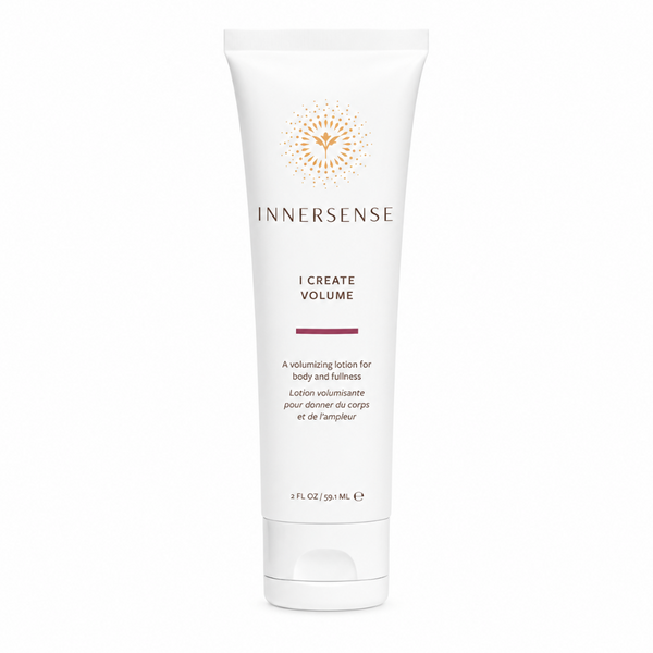 A white tube of Innersense I Create Volume volumizing lotion with gold and dark red text and logo, centered on a plain white background.