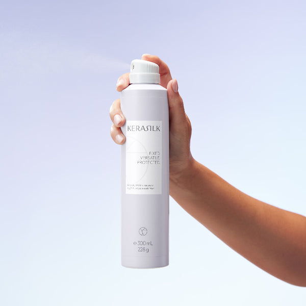 Hand holding a KERASTILK product against a light purple background