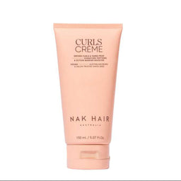 A tube of NAK HAIR Curls Creme hair product in a soft peach-pink color, centered on a plain white background.