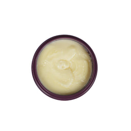 A top-down view of a round jar filled with a pale yellow cream or balm, set against a plain white background.