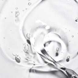 Close-up of water droplets on a clear surface with a light gray background
