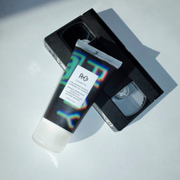 a tube of R+Co Cassette Curl Defining Masque on top of a cassette