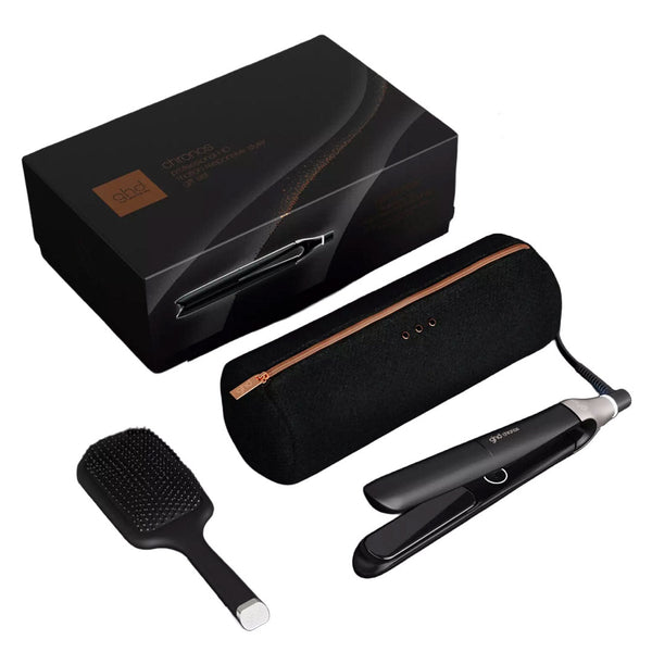 A hair styling kit on a white background, including a black flat iron, a black paddle brush, a black cylindrical carrying case with a rose gold zipper, and a black presentation box.