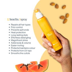 A hand holds a bottle of Morinda 12 benefits.1 spray hair product against a warm beige and yellow graphic background with scattered almonds and papaya slices.