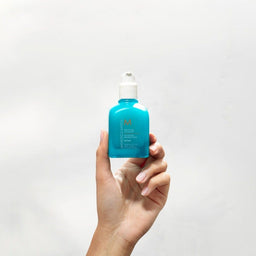Moroccanoil Mending Infusion being held to the air